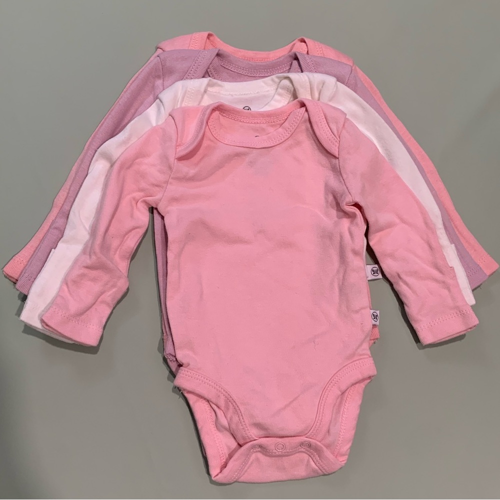 Honest company bundle of onesies in Pink hues.